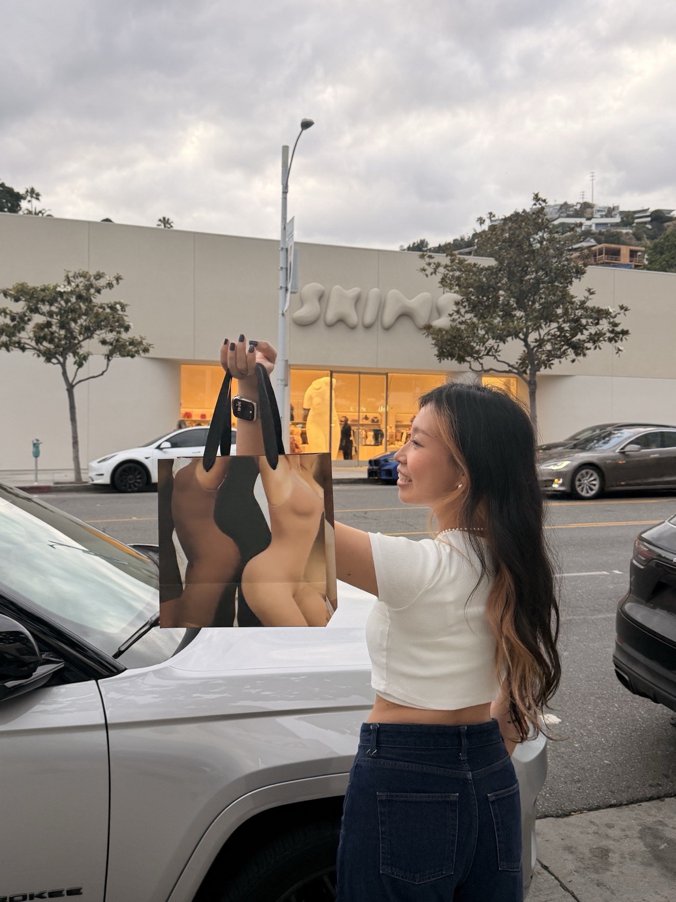 zzx holding a SKIMS shopping bag outside the store