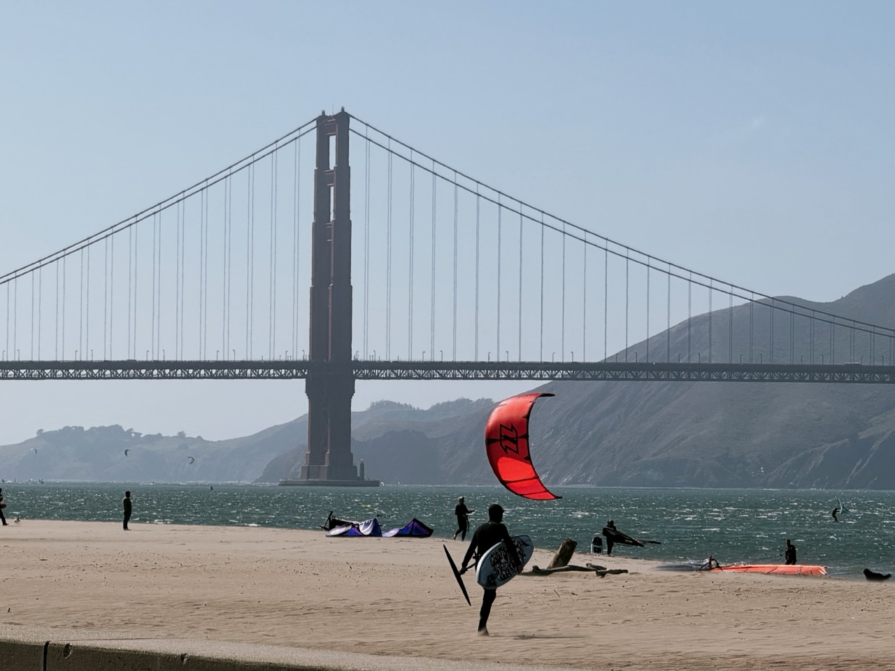 The Golden Gate Bridge, beach, wind, and a kite surfer